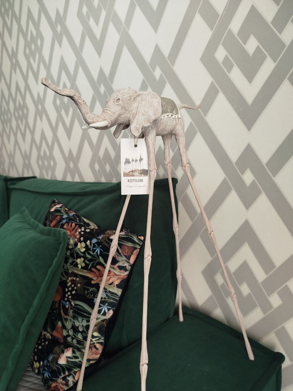 Белая статуэтка слона Дали у изумрудного дивана — контрастная композиция в стиле Сальвадора Дали