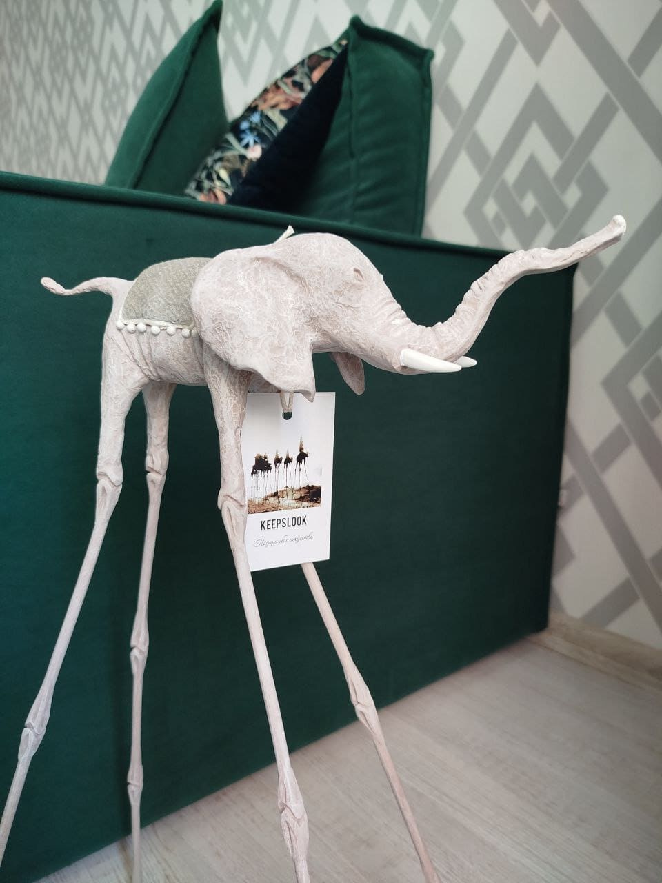 Белая статуэтка слона Дали у изумрудного дивана — контрастная композиция в стиле Сальвадора Дали