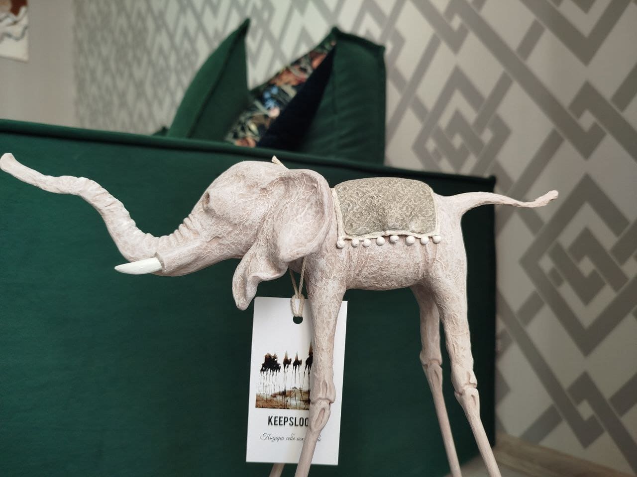 Белая статуэтка слона Дали у изумрудного дивана — контрастная композиция в стиле Сальвадора Дали