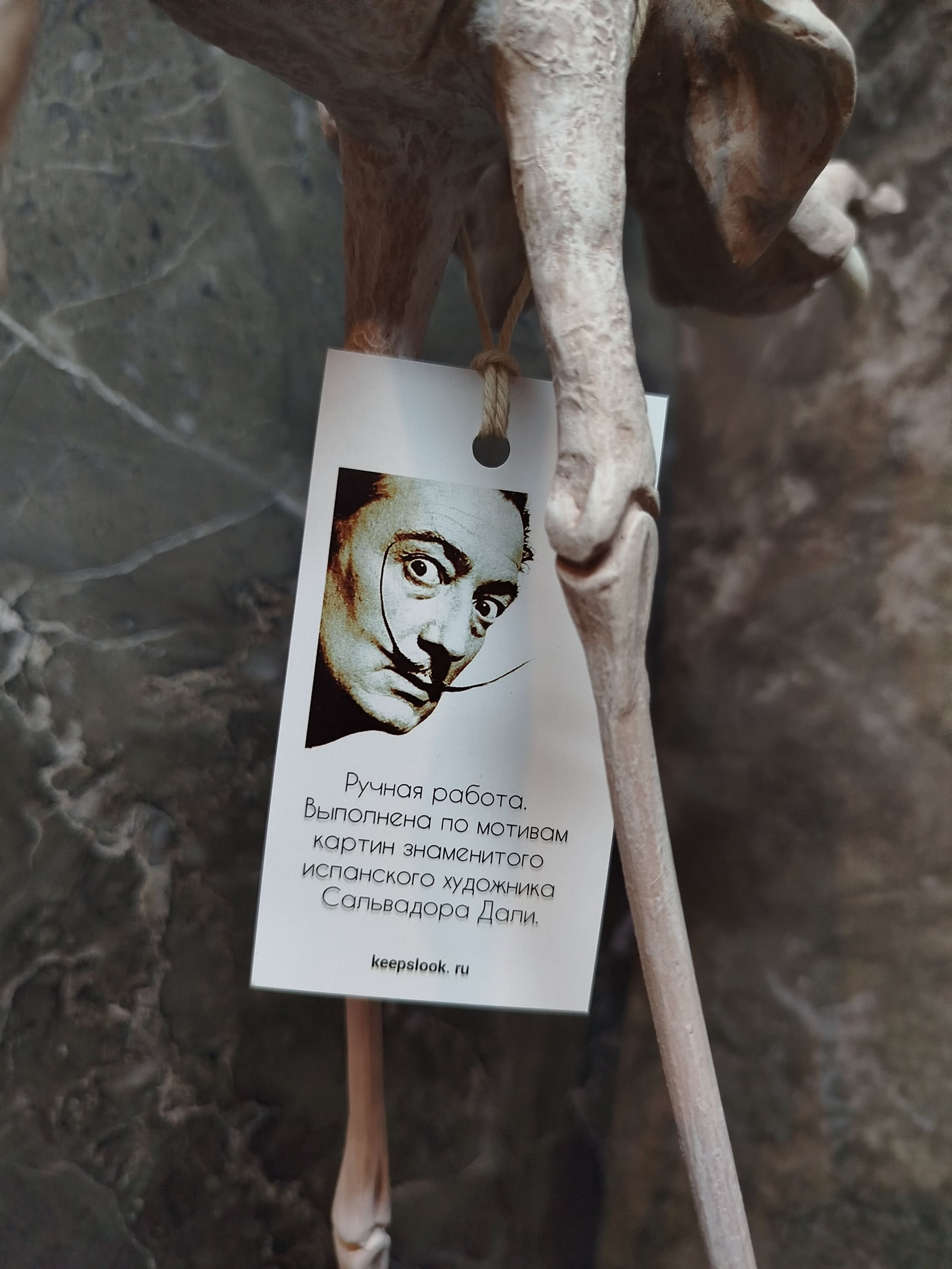 Белая статуэтка слона Дали у светлой стены — минималистичная подача авторского арта