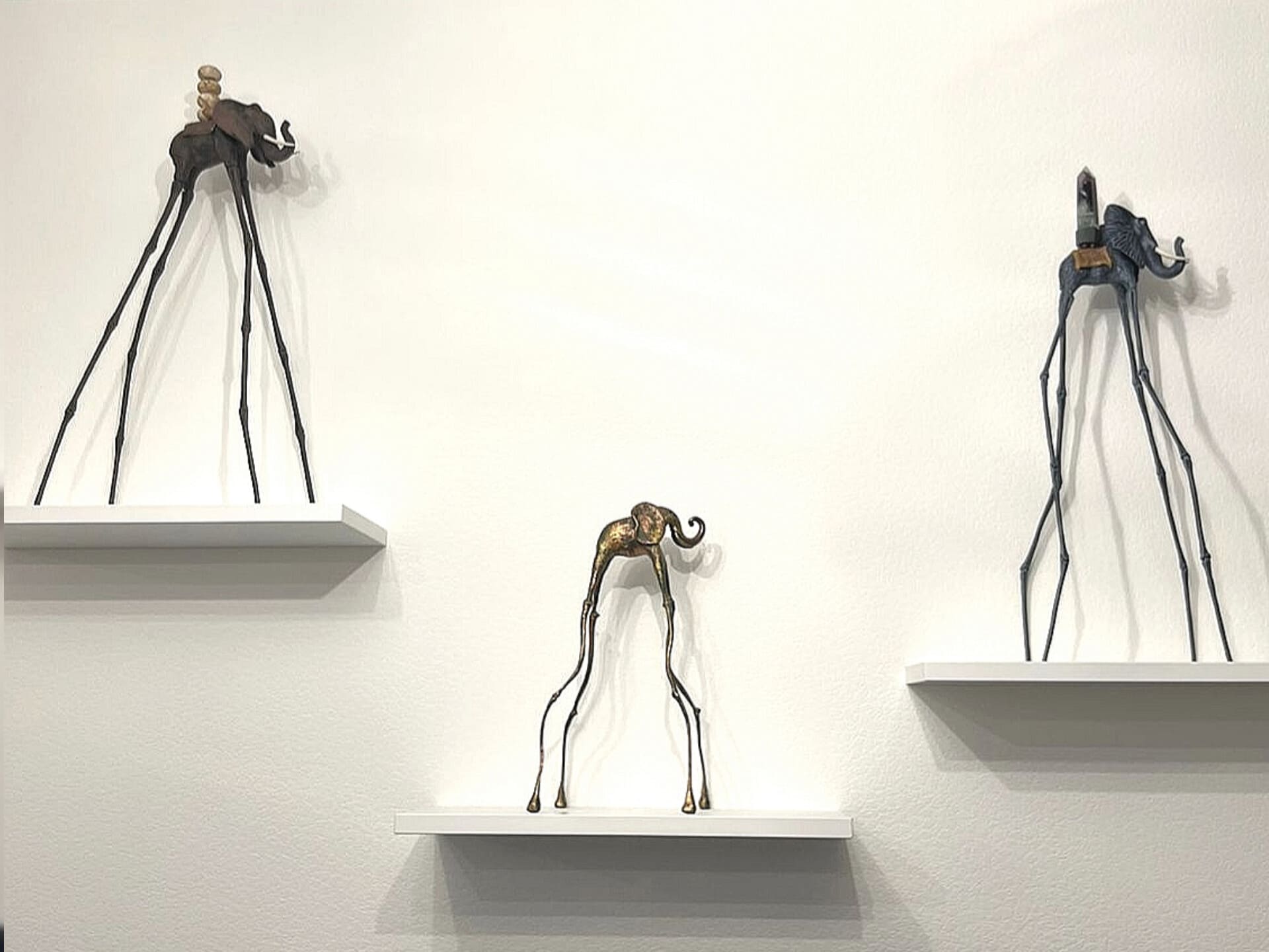 Статуэтки слона Дали на настенных подставках — необычная интерьерная композиция в стиле Сальвадора Дали